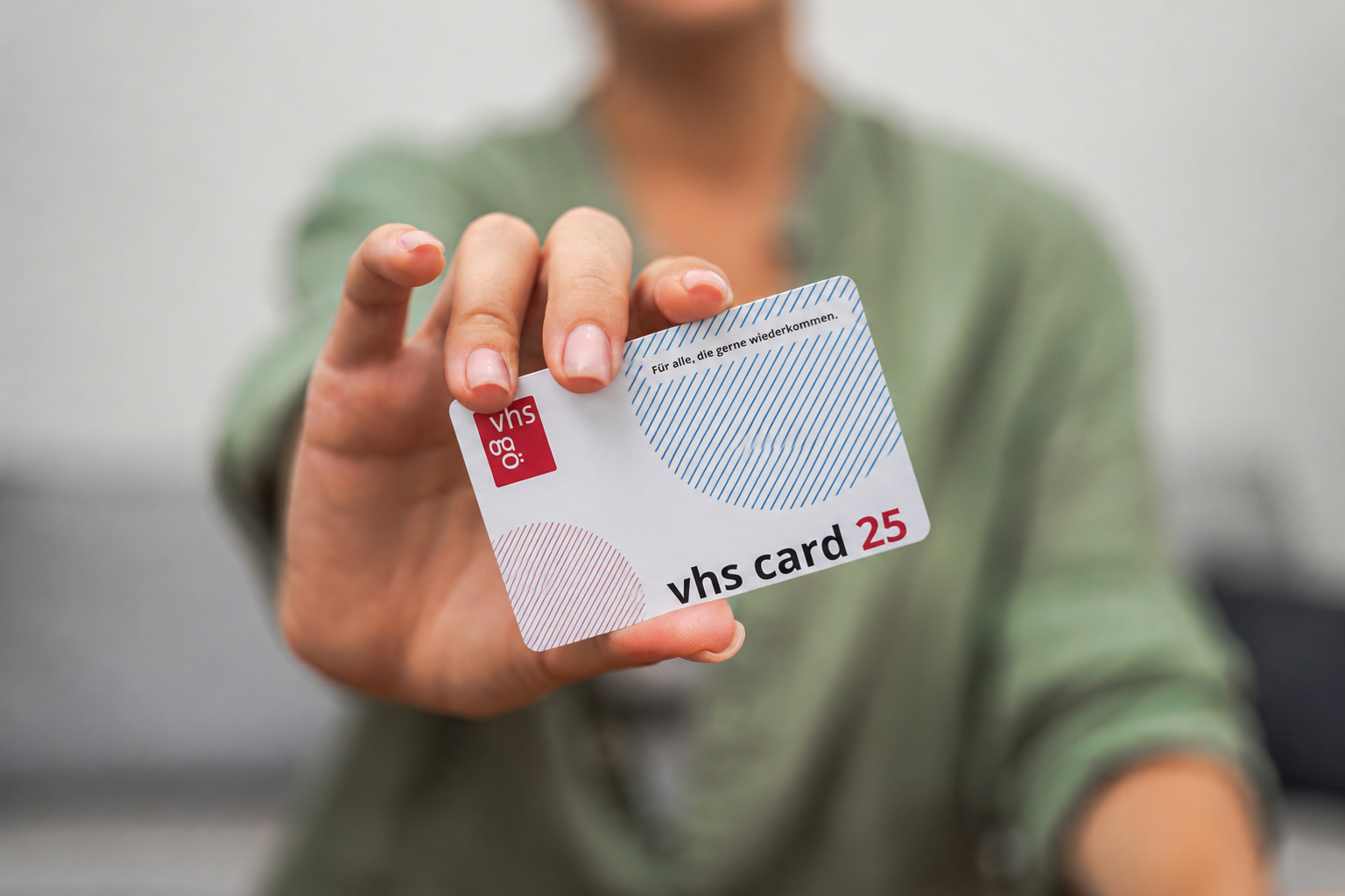 Eine Frau hält die vhs card 25 in der Hand