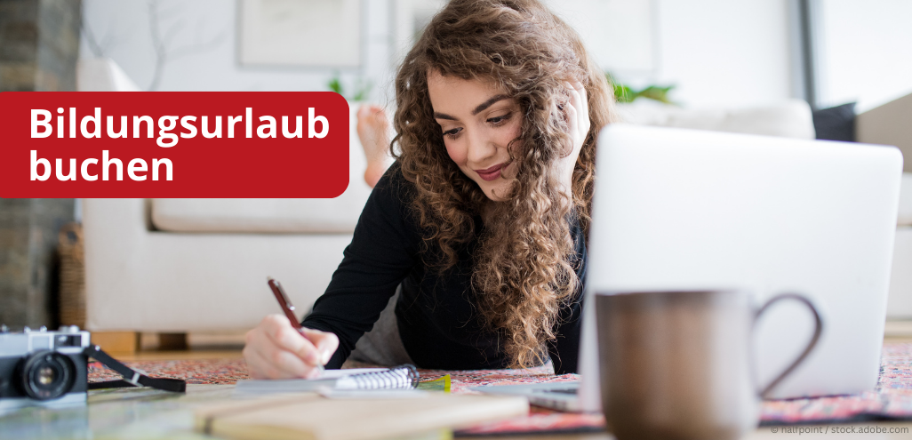 Eine Frau sitzt vor dem Computer und schreibt Notizen.